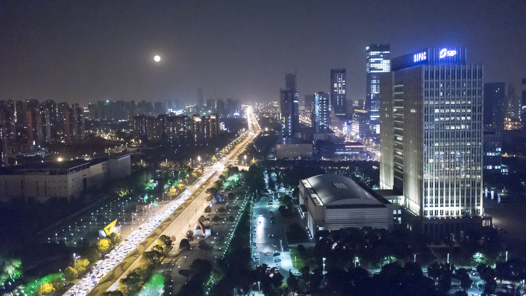 Foto einer Stadt bei Nacht mit beleuchteten Straßen und Gebäuden