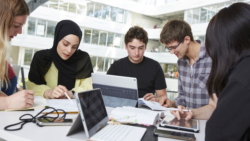 Bild einer Studierendengruppe um einen Laptop